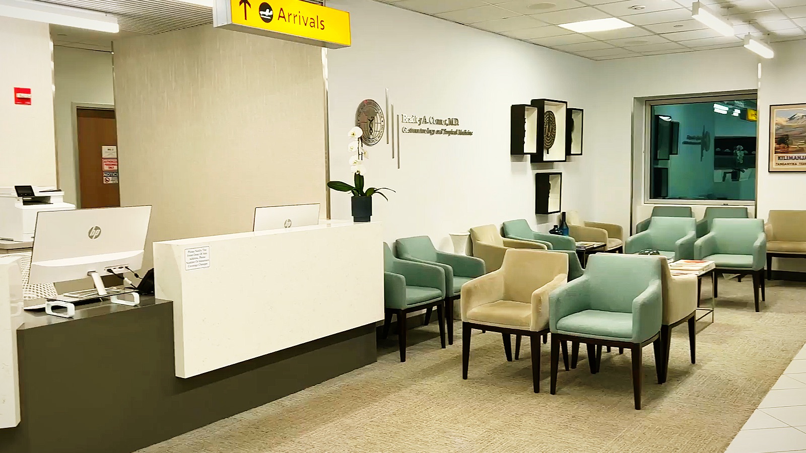 Reception desk and waiting area at The New York Center for Travel and Tropical Medicine, with a yellow airport style Arrivals sign above the front desk